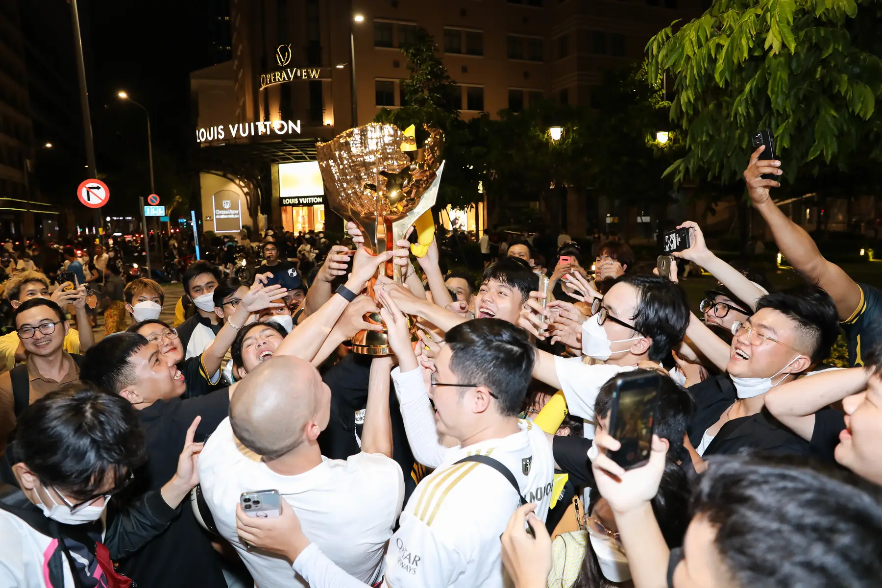 Fans reaching for the trophy in the street at the victory parade
